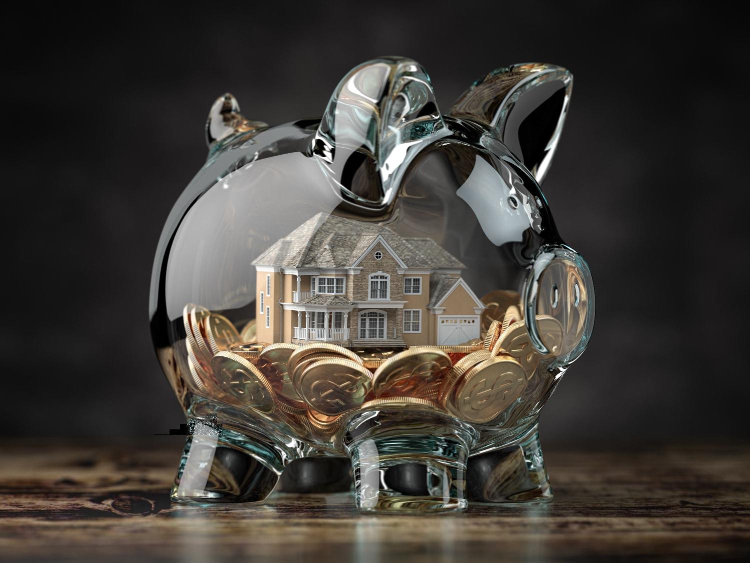 Glass piggy bank with coins and house inside